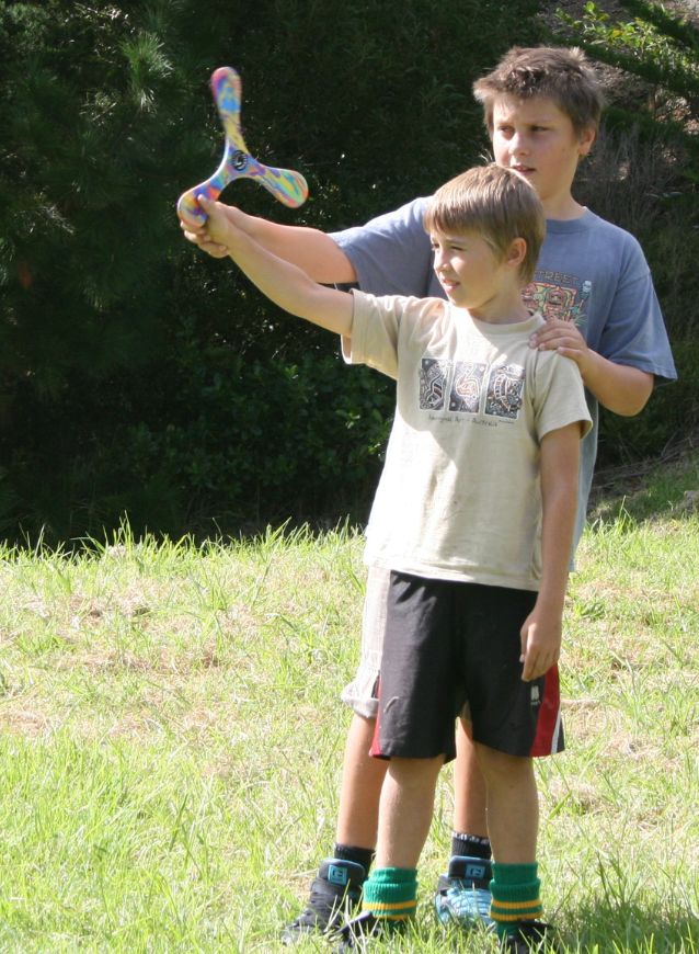 Two boys playing with an outdoor Superang Boomerang