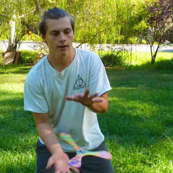 Teenager catching FlyingToyz Superang foam boomerang in grassy area